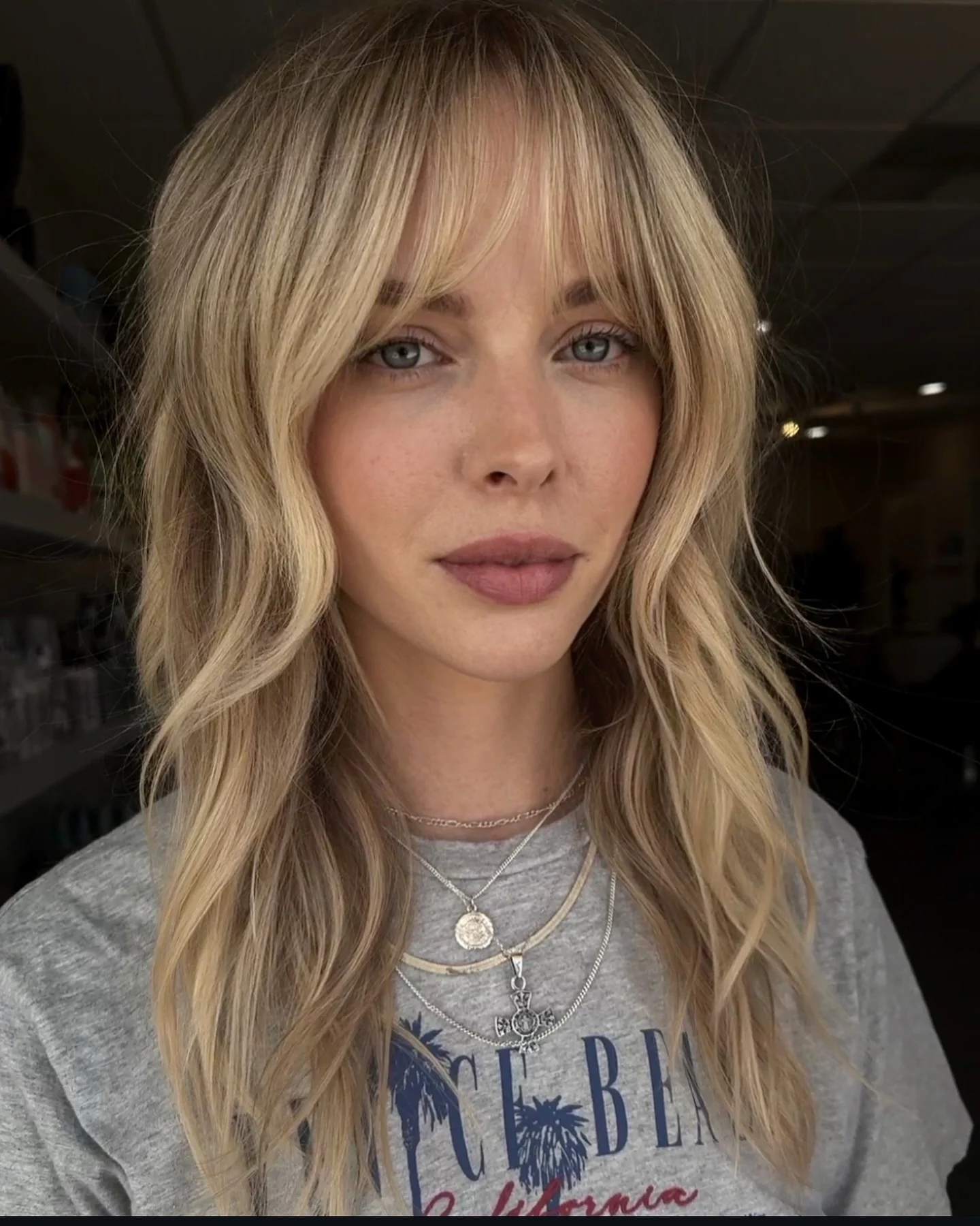 11. Cremiger blonder Shag mit weichem Vorhang-Pony (zotteliger Haarschnitt mit Pony)