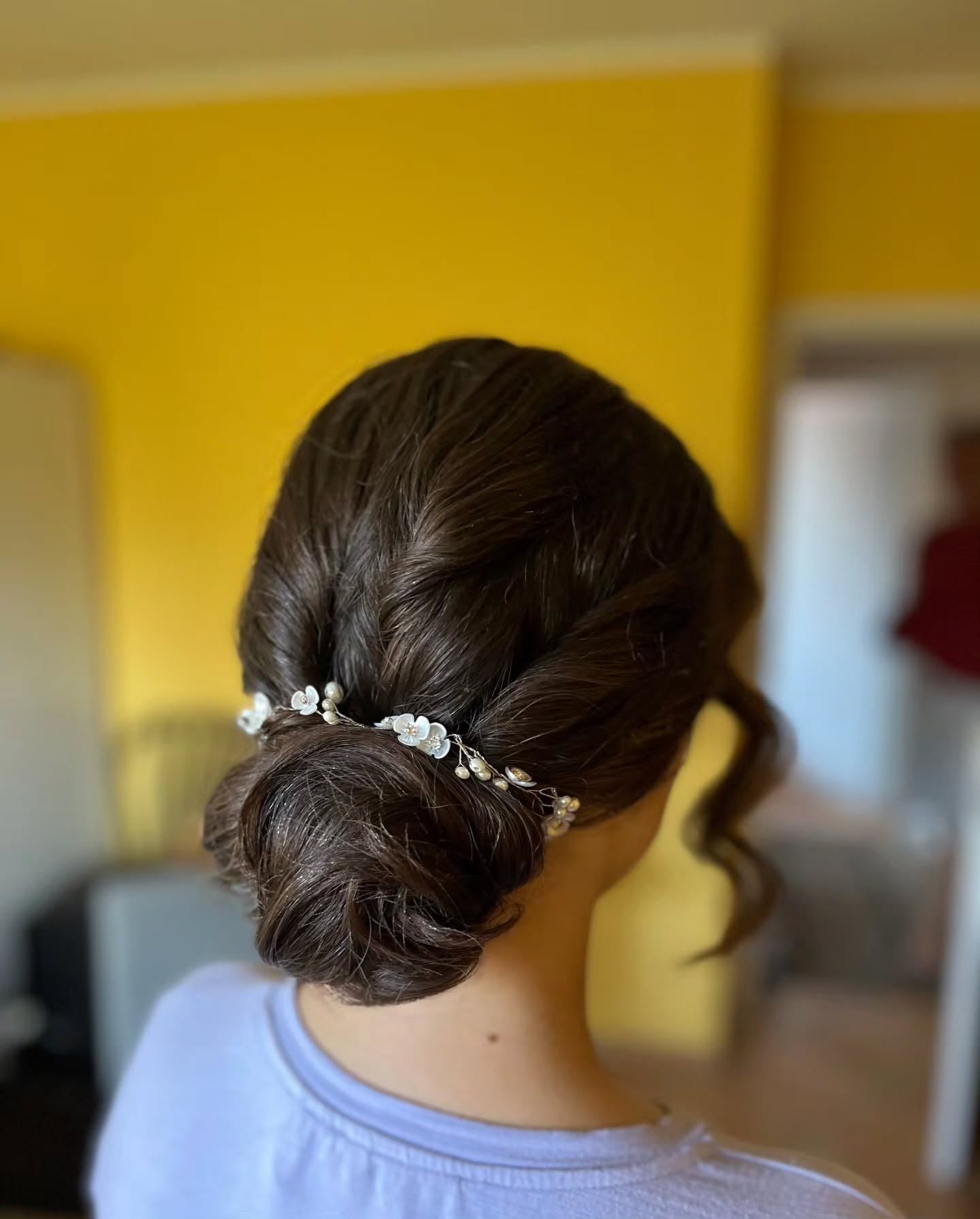 11. Niedriges Brötchen mit Blumenperlenakzent auf dunkler Brünette (Brötchenfrisuren)