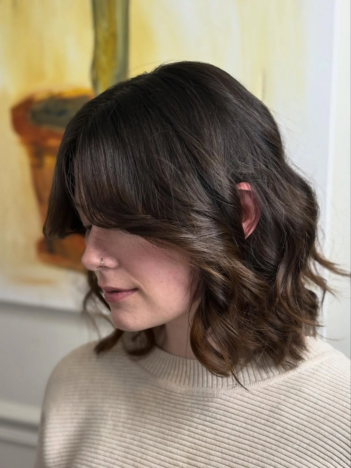 12. Geschichtete brünette Wellen mit seitlich geschwungenem Pony (schulterlanges Haar)