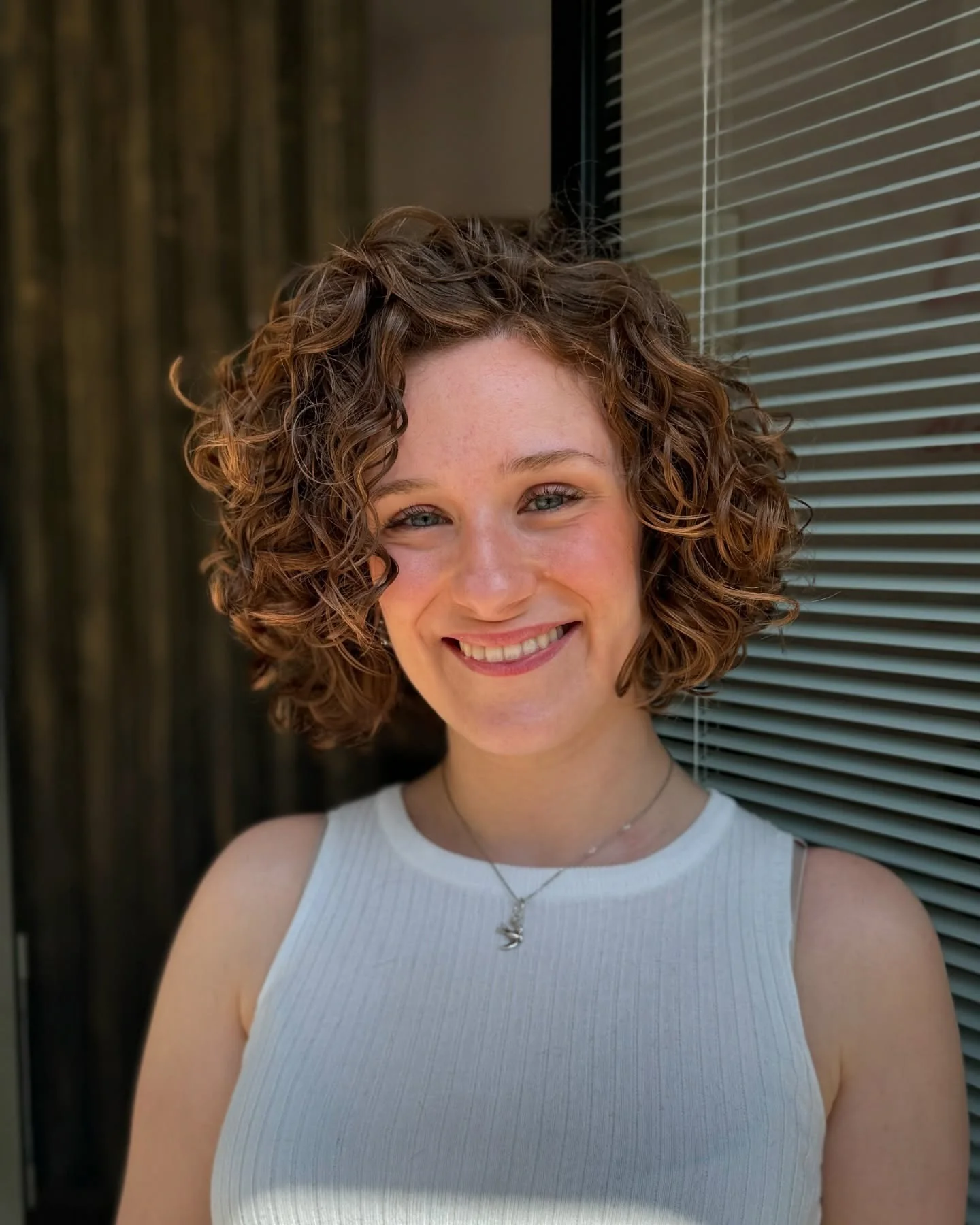 14. Kinnlanger lockiger Bob mit goldbraunen Akzenten (kurze lockige Frisuren)