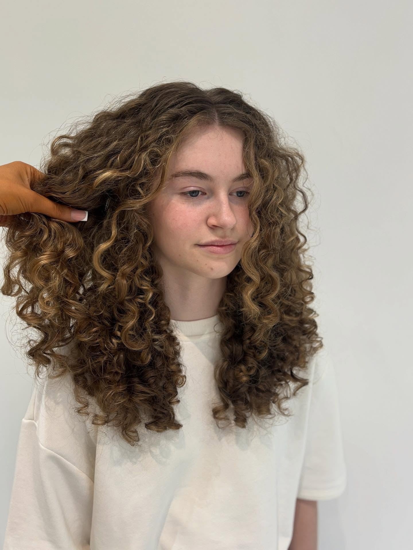 14. Lange lockige Schichten mit honigbraunen Highlights (lockige Frisuren)