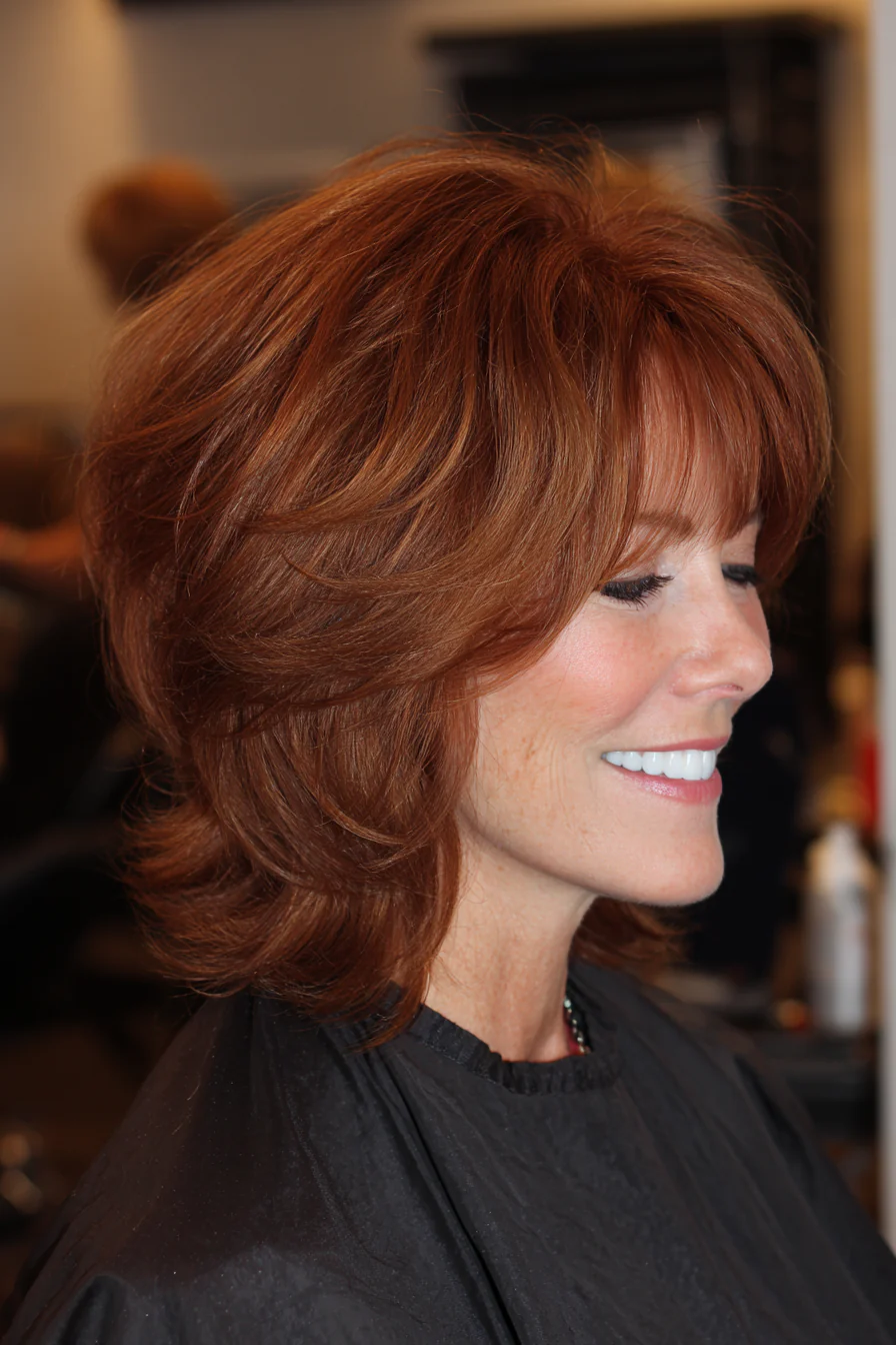 23. Weicher Auburn Shag mit zartem Pony (Trendfrisuren für Frauen über 60) – Trendfrisuren für Frauen über 60