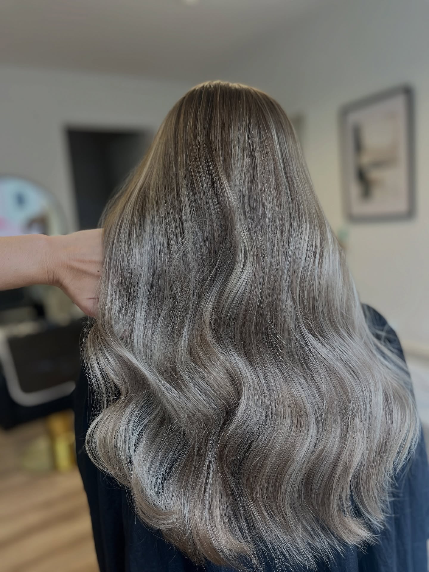 3. Kühles Aschbraun, das zu silbernen Aschblond-Wellen verschmilzt (Aschblonde Haarfarbe)