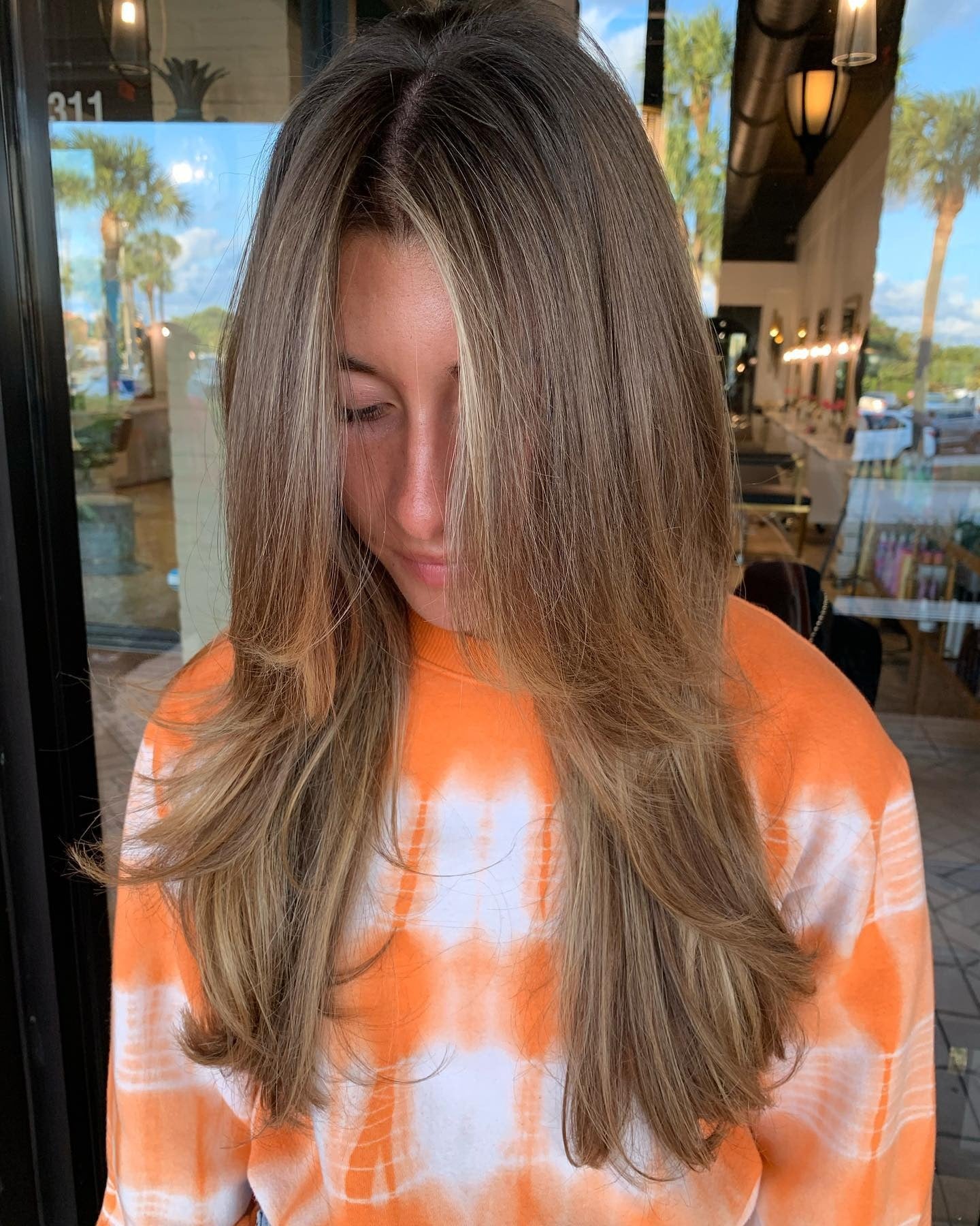 4. Sonnenbeschienene Bronde-Schichten mit leichtem Vorhanglift (lange Stufenfrisuren)