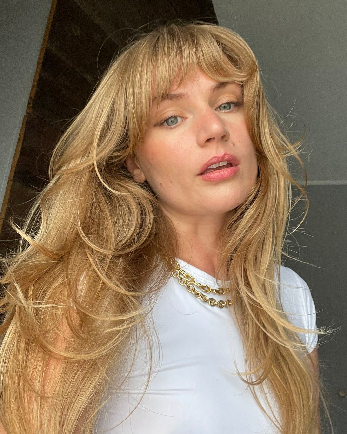 5. Butterblonde Schichten mit luftigen Gesichtsrahmen (Wispy Bangs-Frisuren)