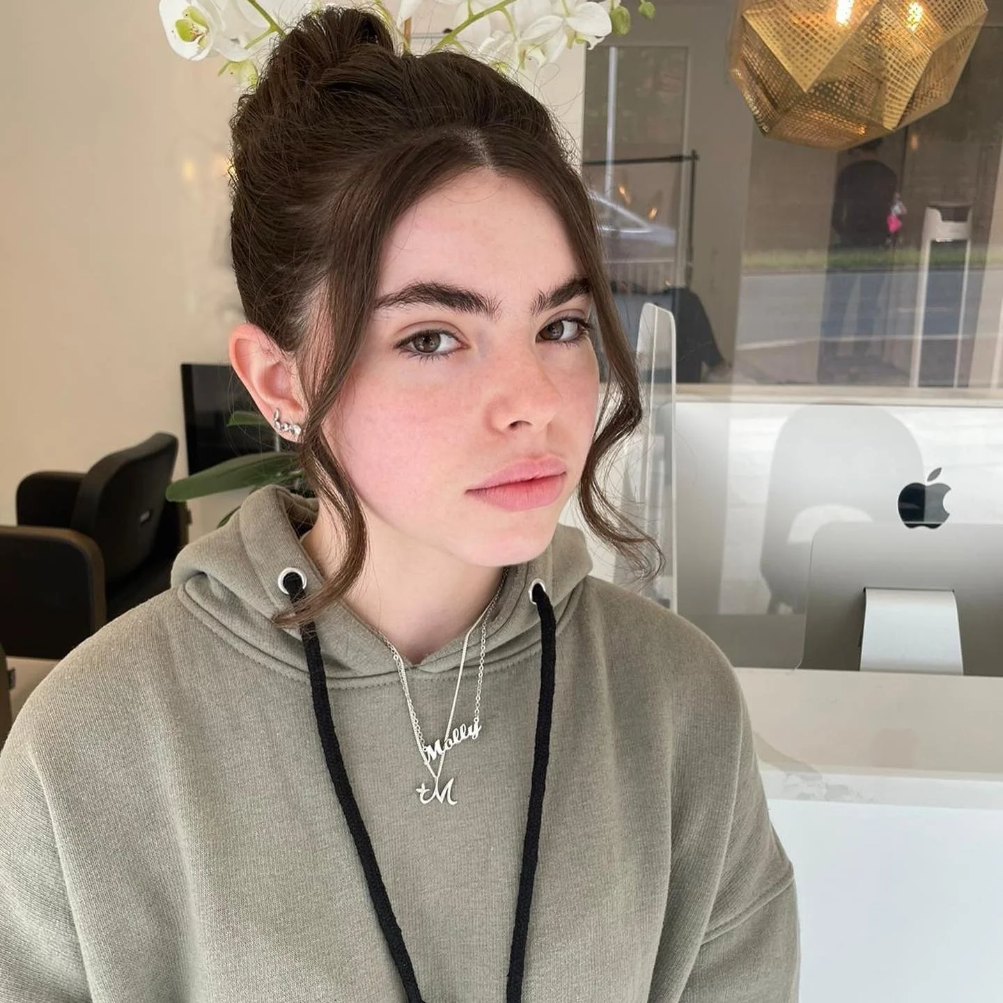 5. Glänzender brünetter Dutt mit gesichtsumrahmenden Locken (Top-Knoten-Frisuren)