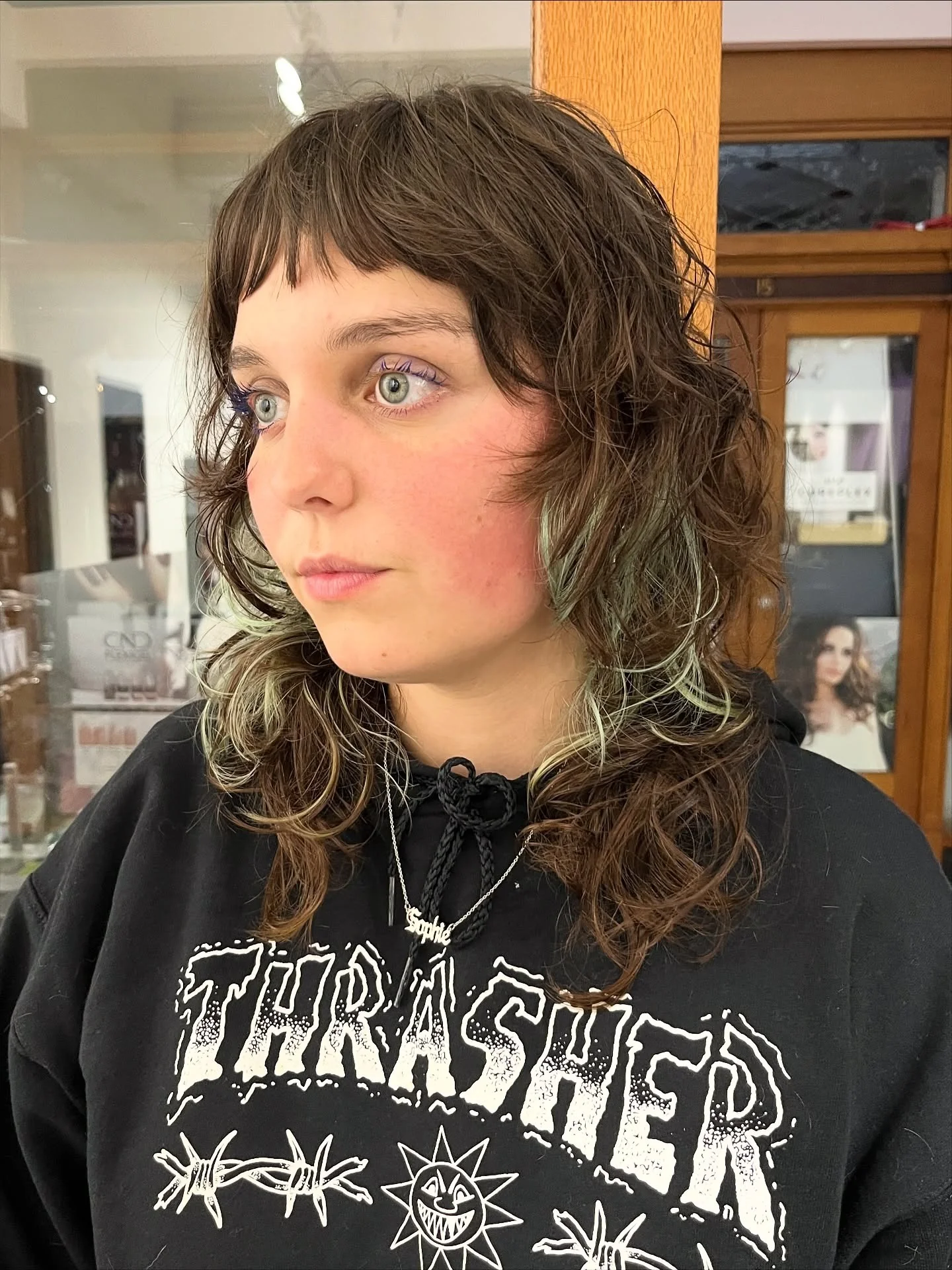 6. Lockiger Wolfsschnitt mit mintfarbenen Akzentstreifen und abgeschnittenen Fransen (Wolfshaarschnitte mit Pony)