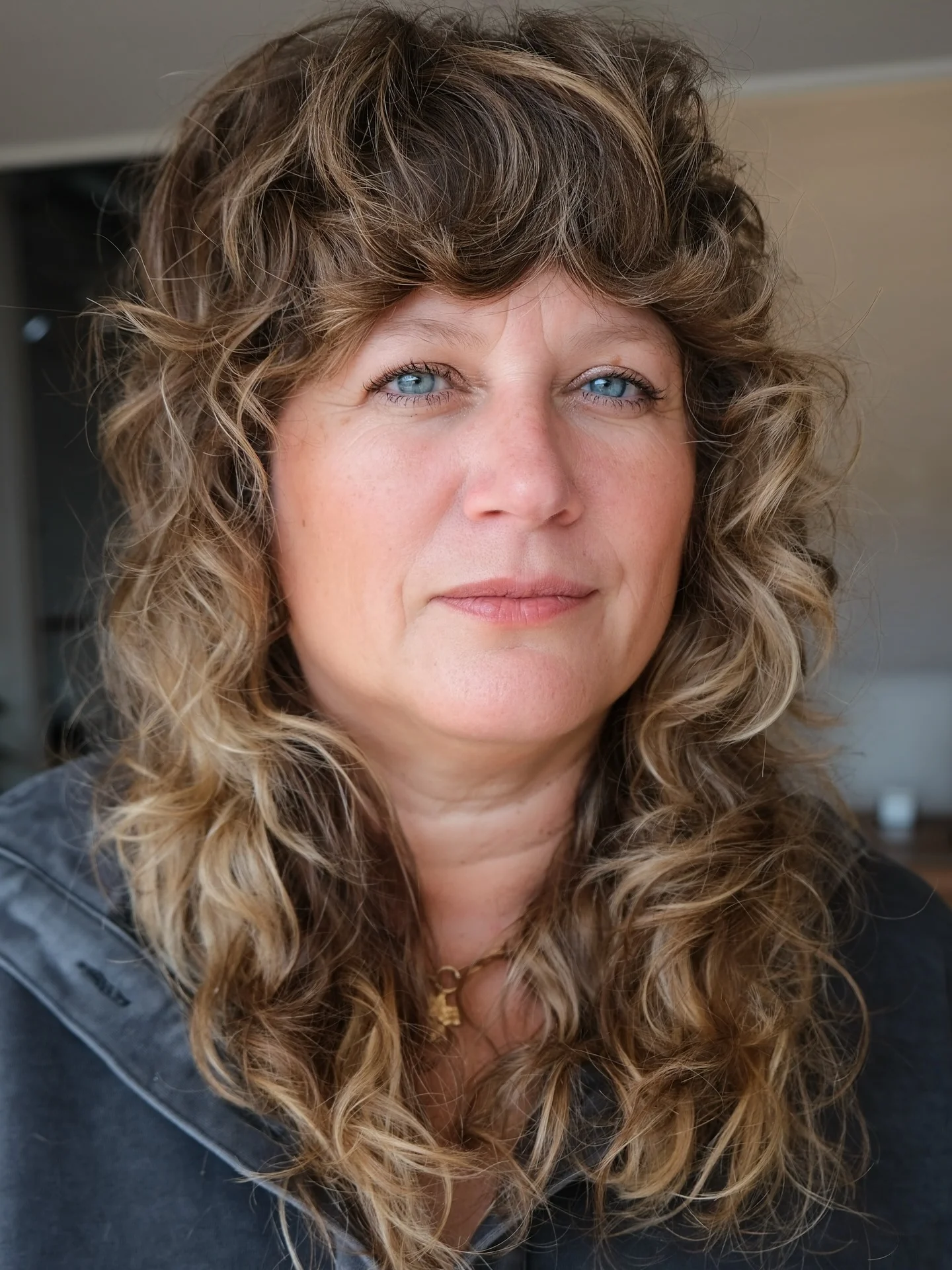 6. Zottelige, lockige Schichten mit Curtain Bangs in Cool Ash Bronde (lockige Frisuren)