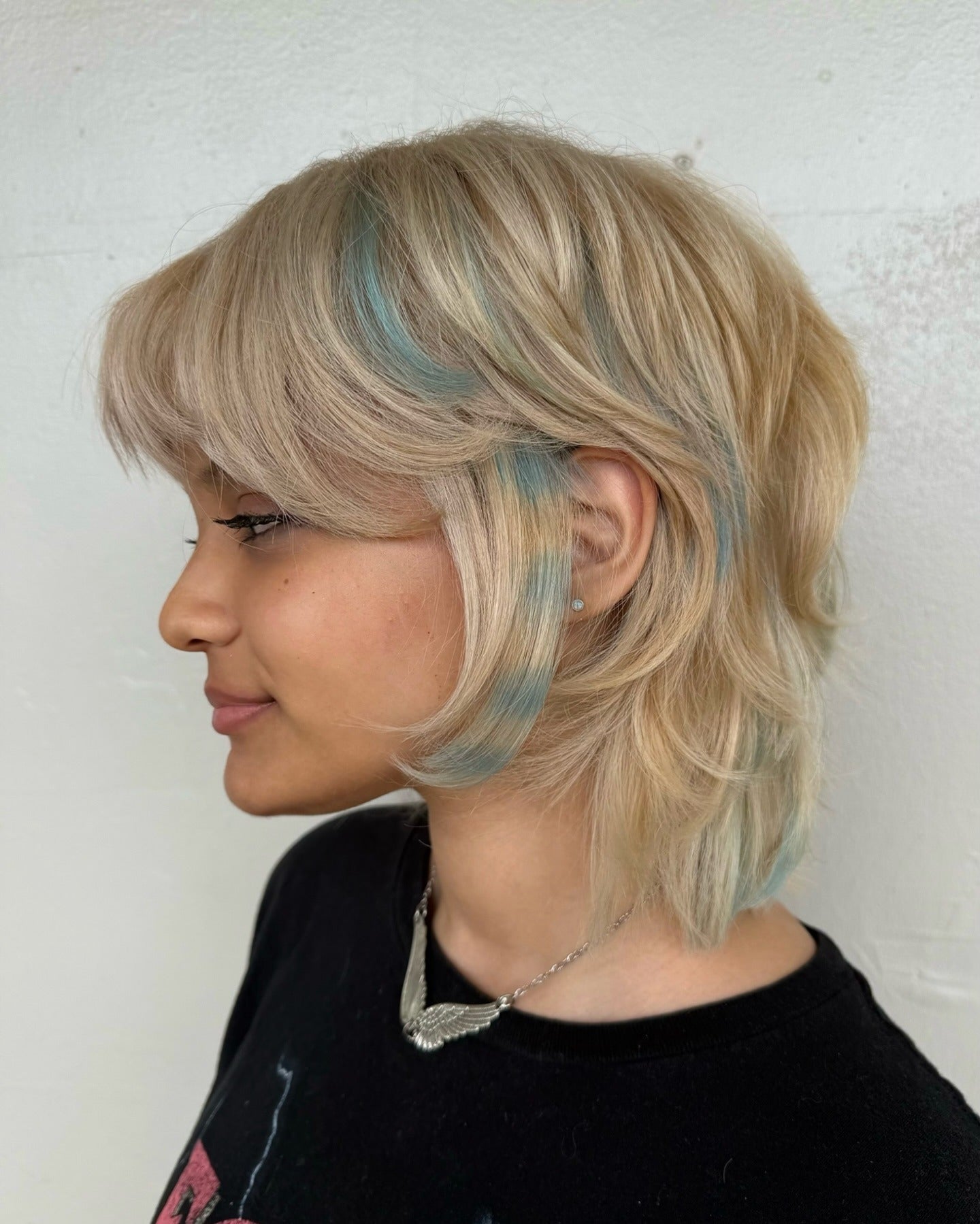 7. Blonde Shag mit blaugrünen Akzentstreifen (kurze Shag -Haarschnitte)