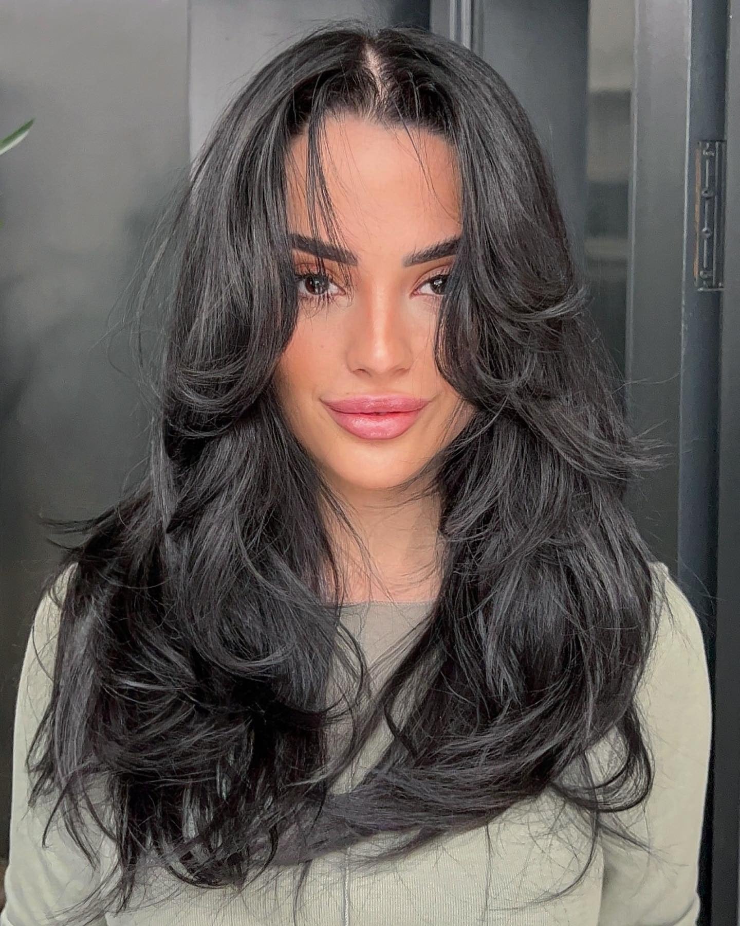 7. Hochglänzende schwarze dynamische Schichten mit geteilten Pony (Frisuren mit Vorhangponsen)