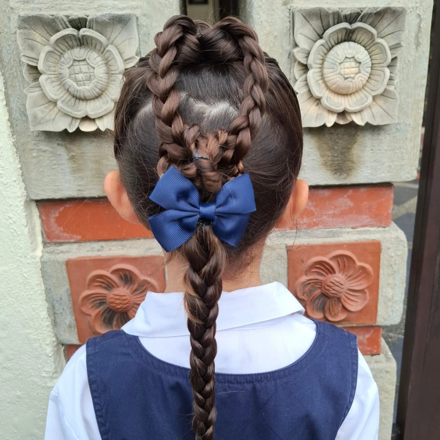 7. Herzgeflecht in lange Zöpfen mit blauer Bug auf mittelbraunem Haar (Frisuren für die Schule)
