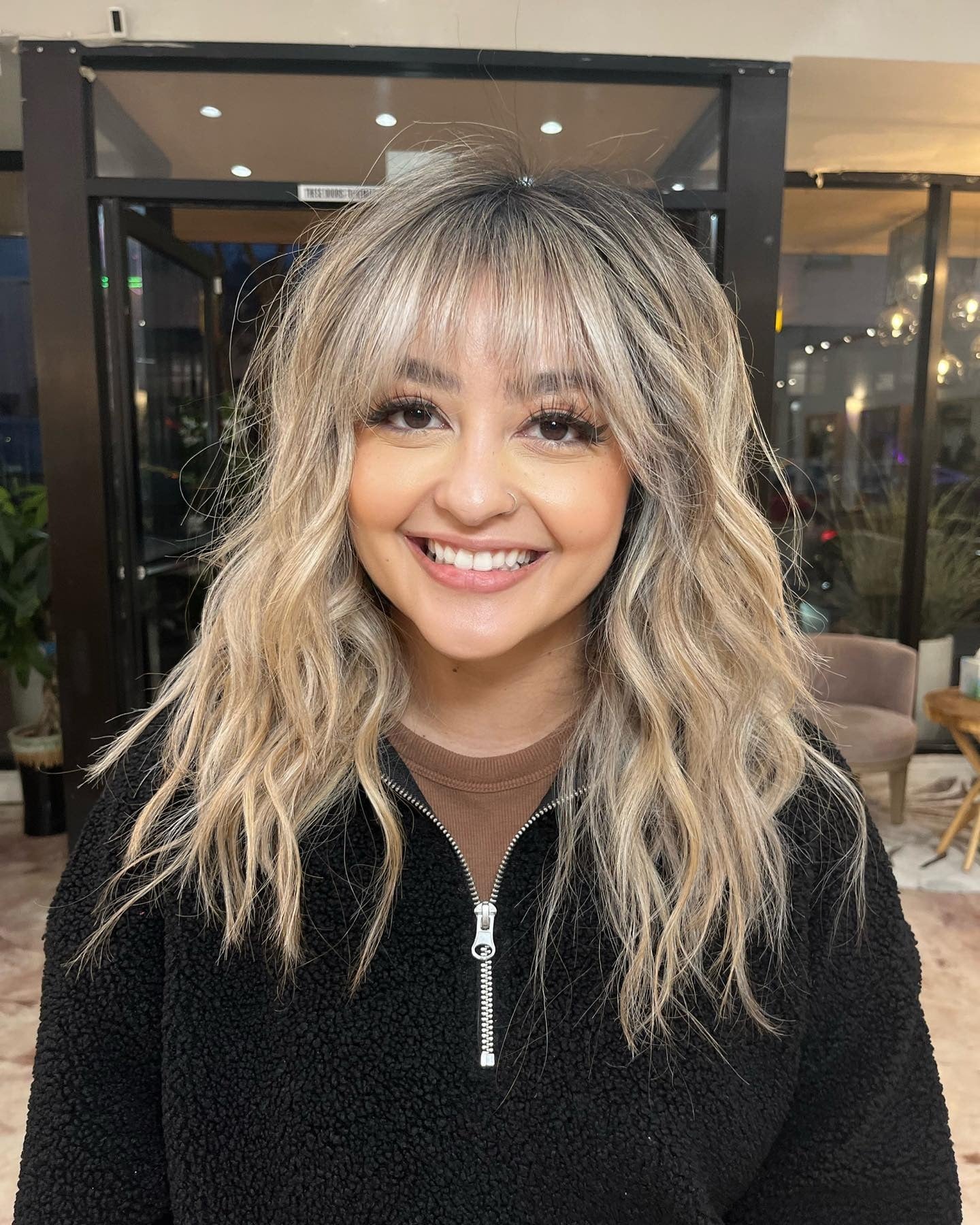 7. Platinblonde Wellen mit Wurzelschatten und Fransen (Bangfrisuren)