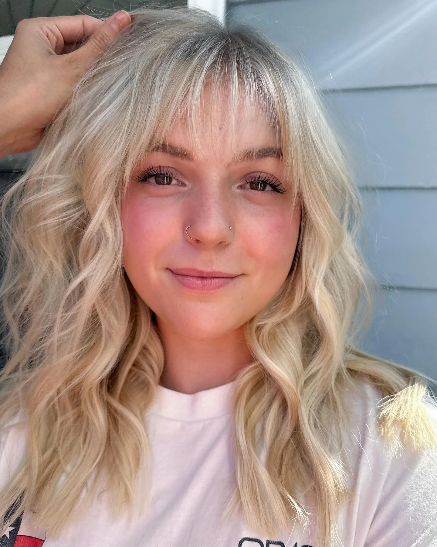 7. Warme blonde Wellen mit zarten Fransen (zotteliger Haarschnitt mit Pony)