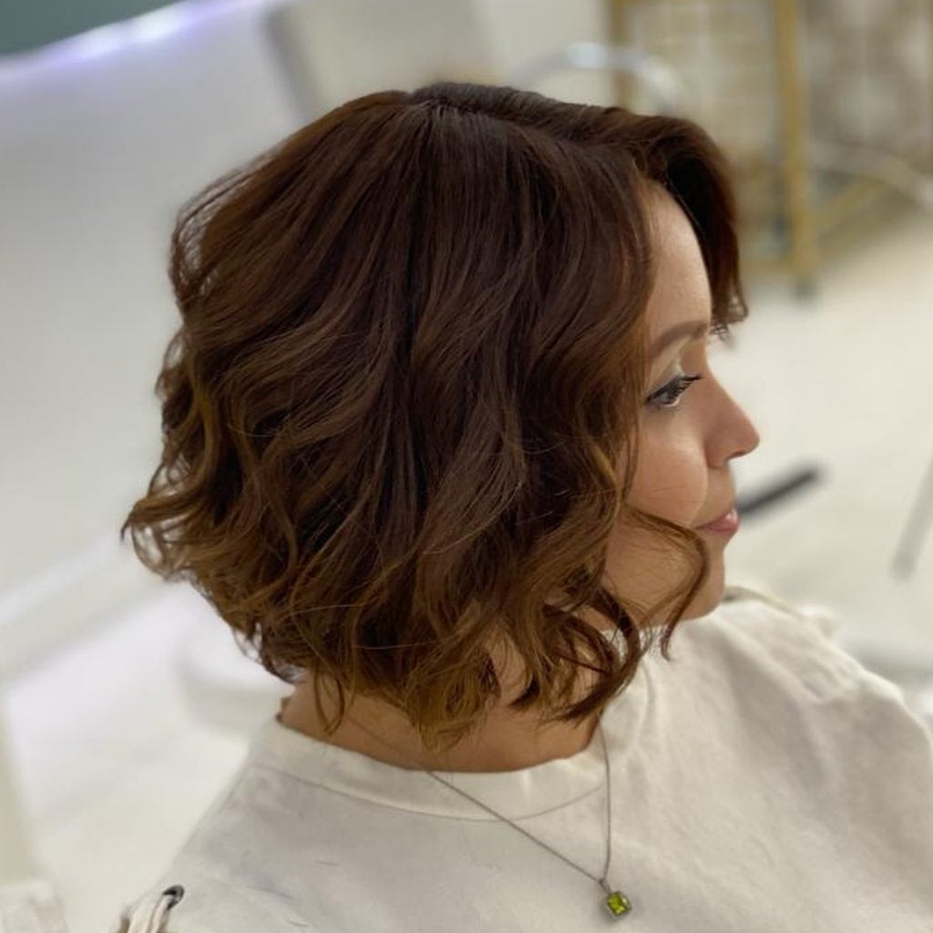 8. Warm Brünette gekräuselte Bob (Frisuren der Chic-Länge)
