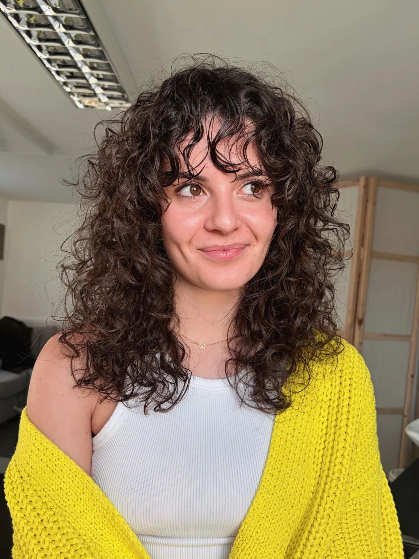 9. Mittlerer lockiger Shag mit zartem Pony in sanftem Espresso (lockige Frisuren)