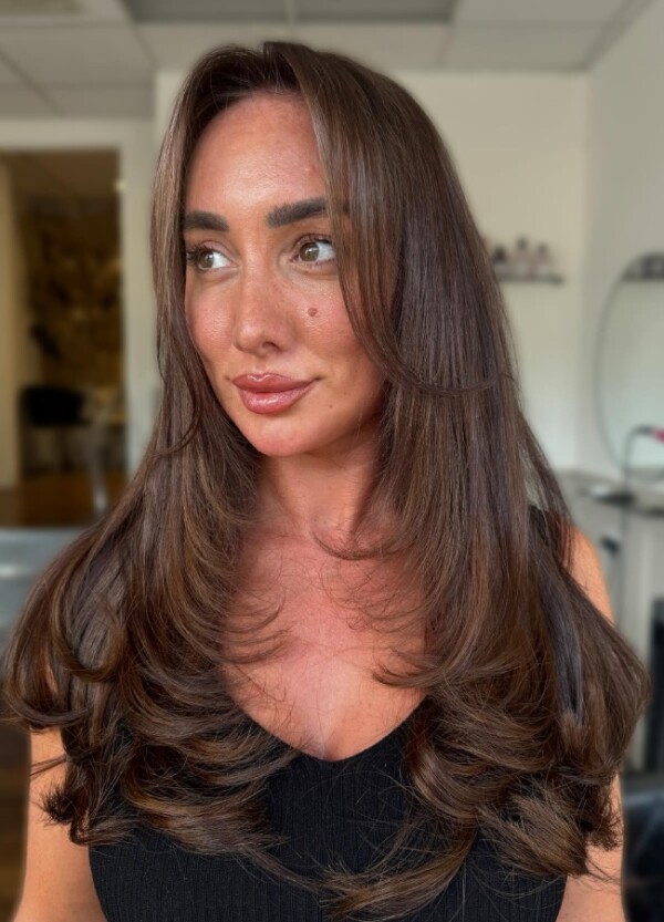 Schokoladenbrünette lange Schichten mit Vorhang-Pony