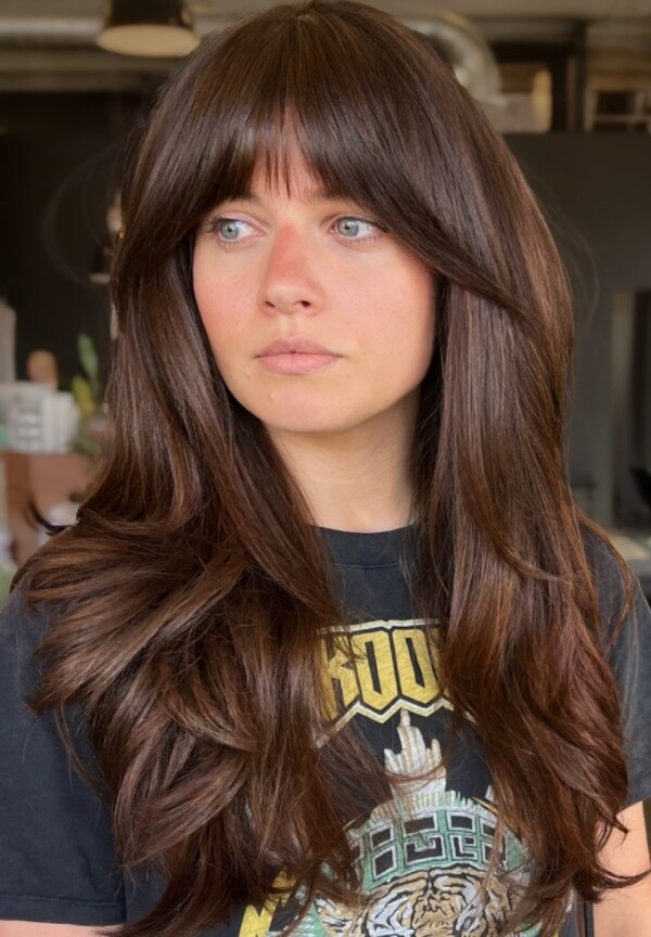 Lange, brünette Schichten im Retro-Stil der 70er Jahre mit vollem Pony 