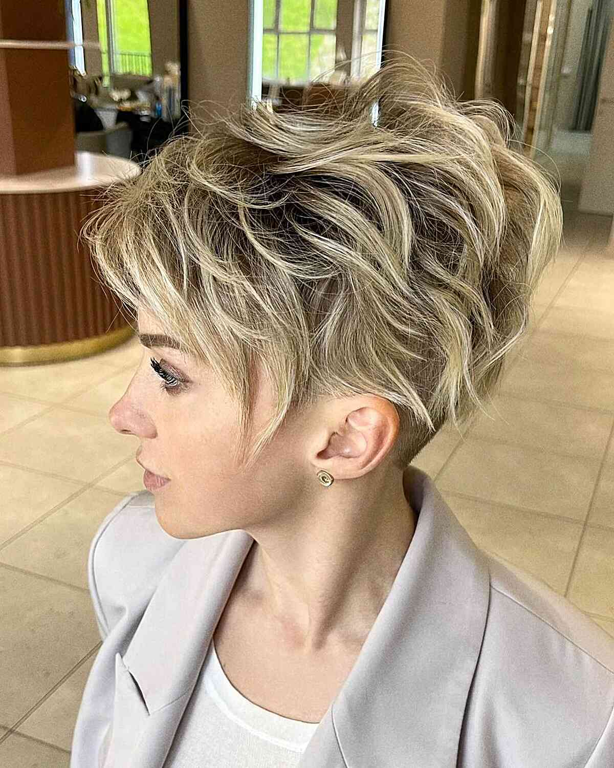 Blonde chaotische lange Pixie geschnitten für Frauen mit kurzen Haaren und dunkleren Wurzeln