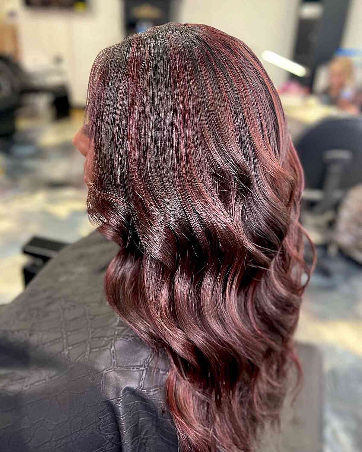 Dunkelbraune wellige Haare mit rot getönten Highlights