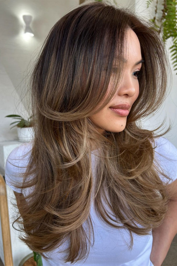 Schmeichelhafte, voluminöse Schichten, die das Gesicht umrahmen, für langes braunes Haar