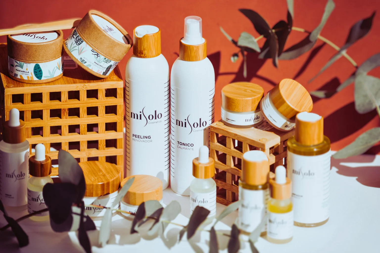 Eine Hand, die Leave-in-Conditioner auf das feuchte geflochtene Haar aufträgt, im Hintergrund ein Satin-Kissenbezug.