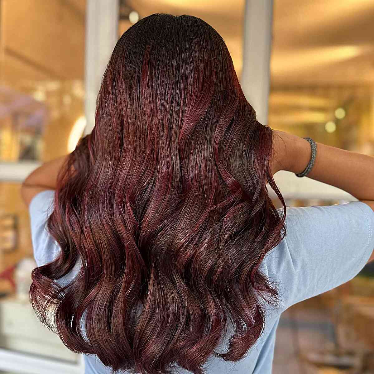 Langlange wellige rote Sangria-Balayage-Highlights auf braunem Haar