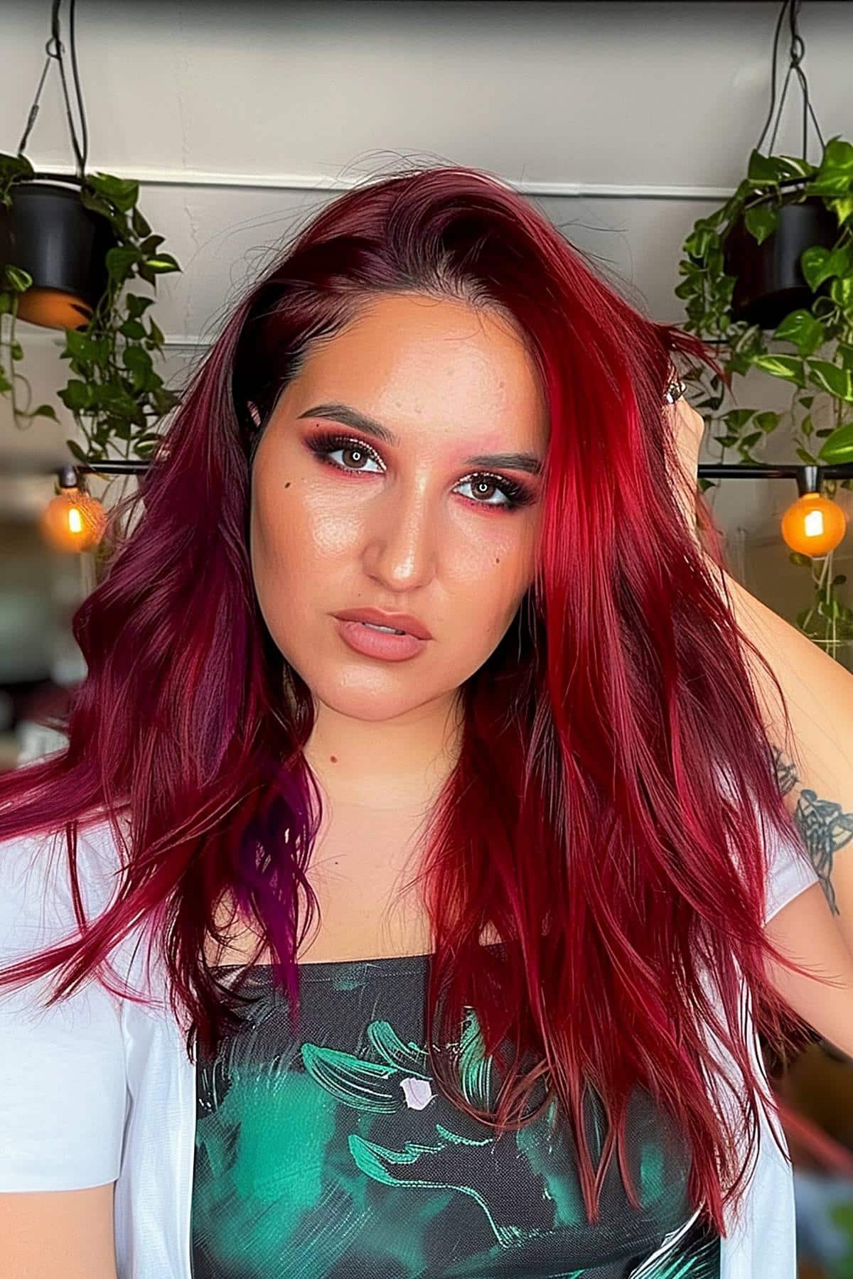 Wellenhaare mit einer dynamischen Mischung aus dunkelrotem mit einer subtilen Verschiebung zu Lila an den Enden.